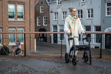 a female parkinson’s patient enjoying a walk outdoors with a walker.